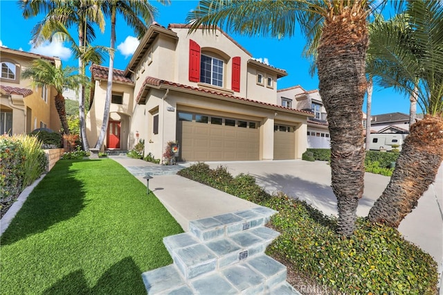 mediterranean / spanish-style house featuring a front yard and a garage