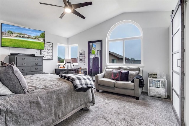 carpeted bedroom featuring vaulted ceiling, a barn door, and ceiling fan