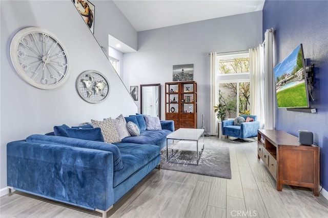 living room with light hardwood / wood-style flooring and a high ceiling