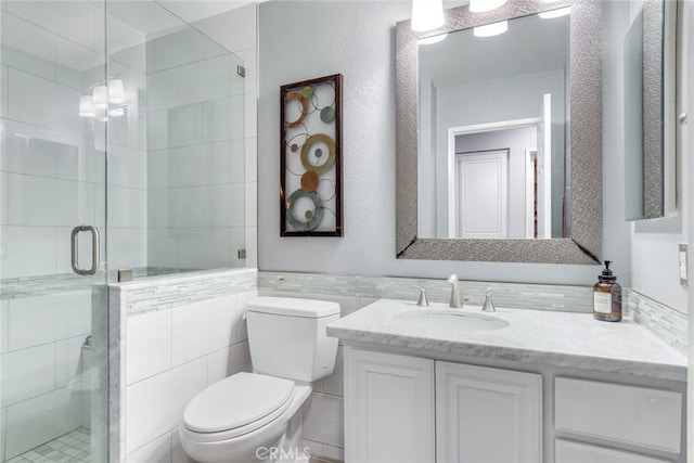 bathroom with walk in shower, vanity, toilet, and tile walls