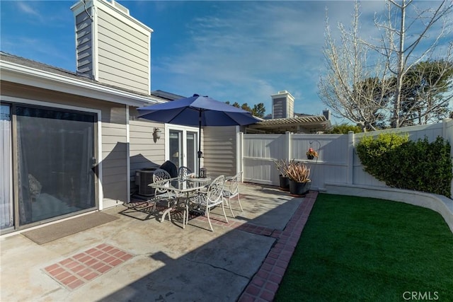 view of patio / terrace featuring outdoor dining space, cooling unit, and a fenced backyard