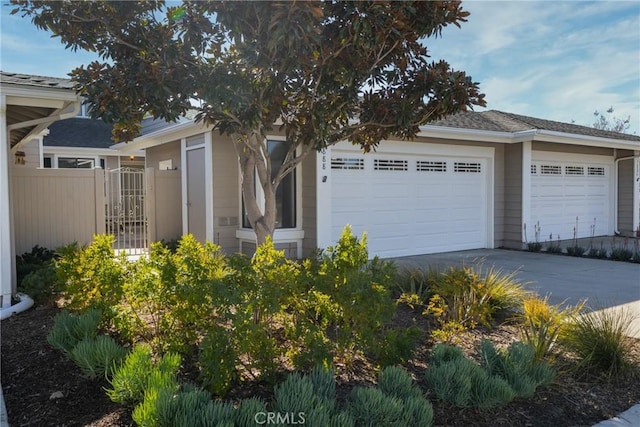 garage with driveway and fence