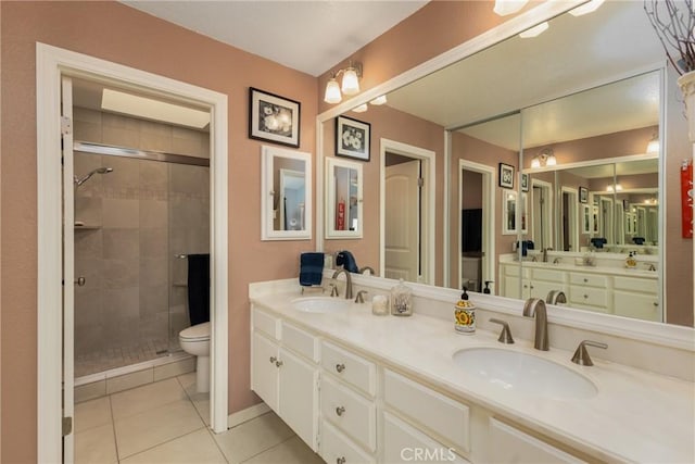 bathroom with tile patterned flooring, toilet, a sink, a shower stall, and double vanity