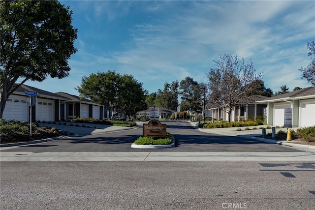 view of road featuring a residential view, street lights, and curbs