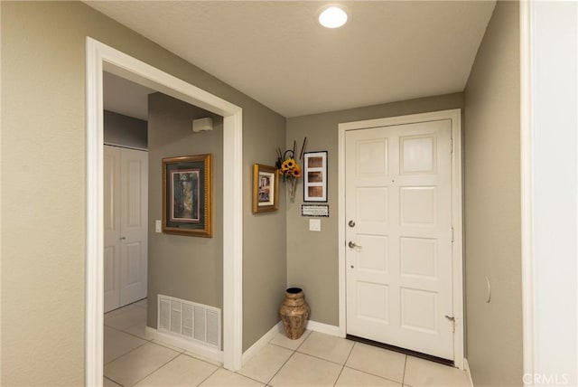 foyer with visible vents, baseboards, and light tile patterned flooring