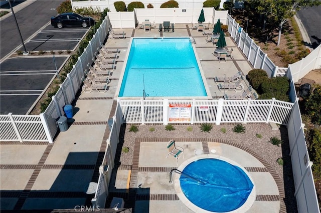 community pool featuring a patio area and fence