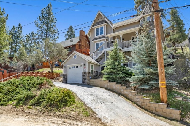 view of front of home featuring a garage, driveway, and stone siding