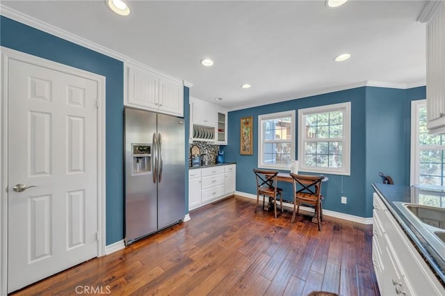 kitchen with white cabinets, stainless steel refrigerator with ice dispenser, dark countertops, dark wood finished floors, and glass insert cabinets