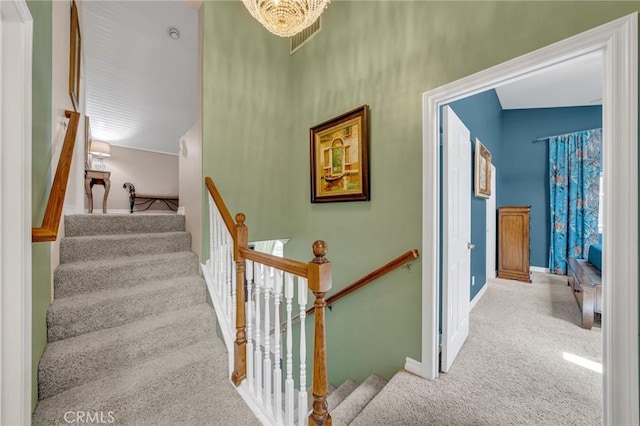 staircase with carpet flooring, visible vents, and baseboards