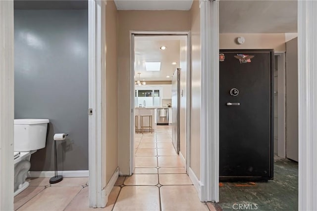 hallway featuring sink and light tile patterned floors