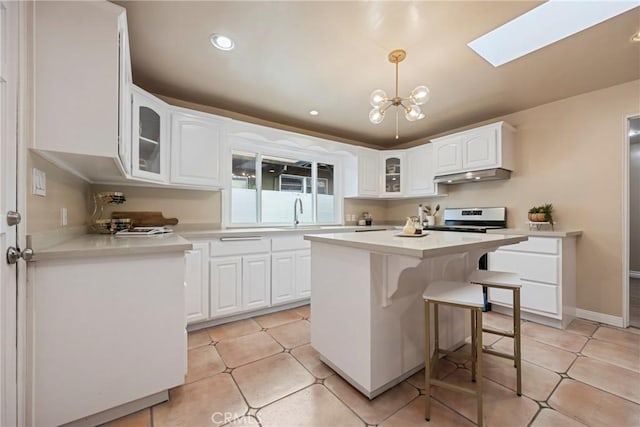 kitchen with stainless steel range with electric cooktop, white cabinetry, decorative light fixtures, a chandelier, and light tile patterned floors