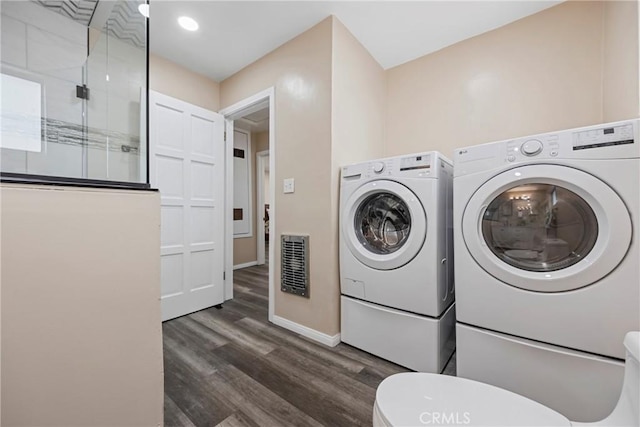 clothes washing area featuring dark hardwood / wood-style floors and washer and clothes dryer