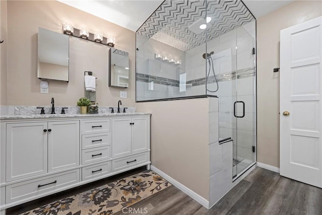 bathroom featuring wood-type flooring, vanity, and a shower with shower door