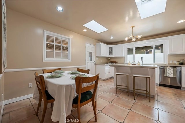 tiled dining room with an inviting chandelier and a skylight