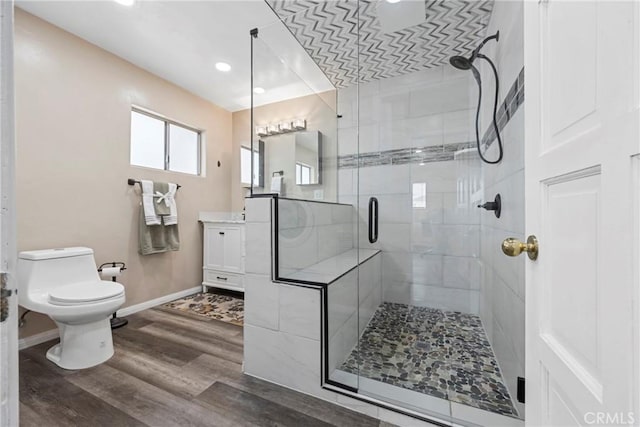 bathroom with vanity, hardwood / wood-style flooring, toilet, and walk in shower