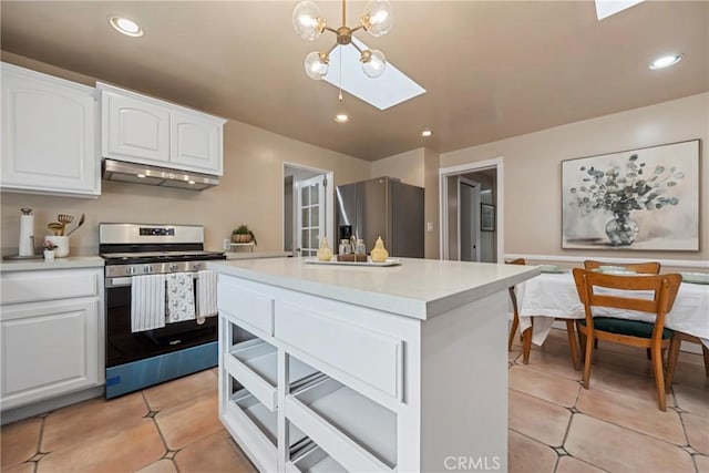 kitchen featuring pendant lighting, stainless steel appliances, light tile patterned floors, and white cabinets