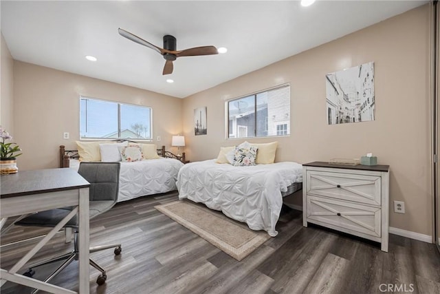 bedroom with multiple windows, dark hardwood / wood-style floors, and ceiling fan