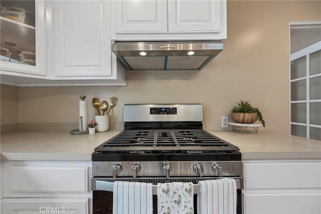 kitchen with gas range, white cabinetry, and exhaust hood