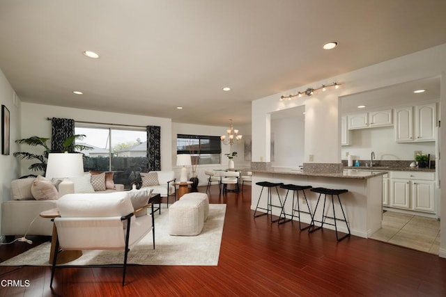 living room with dark hardwood / wood-style floors, a chandelier, and sink