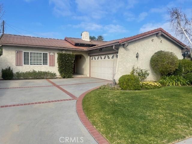 ranch-style house with an attached garage, a front lawn, a tile roof, stucco siding, and driveway