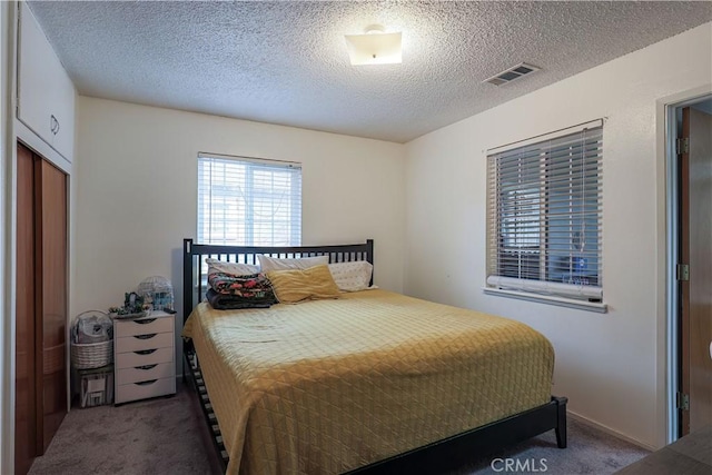 carpeted bedroom featuring a textured ceiling