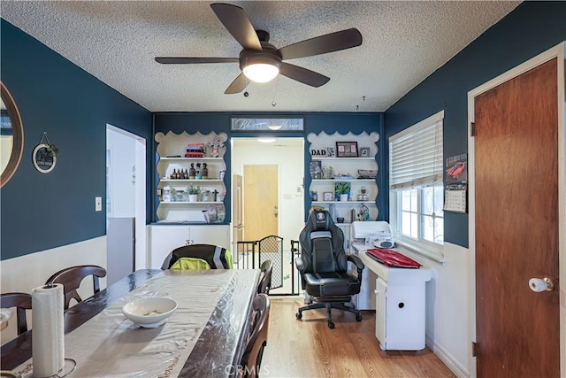 dining area featuring ceiling fan, a textured ceiling, and light hardwood / wood-style floors