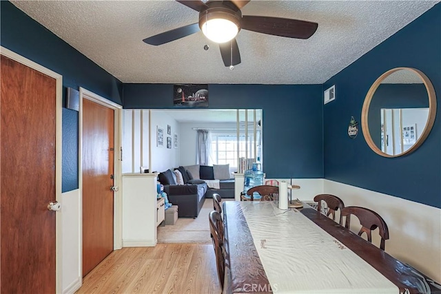 dining area featuring ceiling fan, a textured ceiling, and light hardwood / wood-style flooring