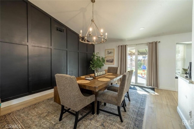 dining space with an inviting chandelier and light wood-type flooring