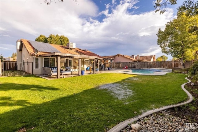 back of house featuring a fenced in pool, a patio, and a lawn