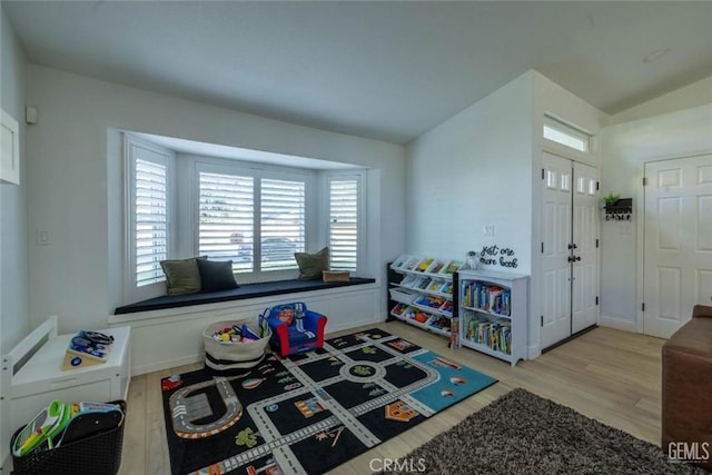 game room with lofted ceiling and light hardwood / wood-style flooring