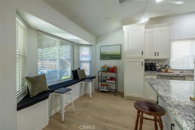 living area featuring lofted ceiling and light hardwood / wood-style flooring