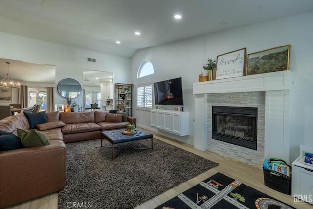 living room featuring an inviting chandelier, a wealth of natural light, and light hardwood / wood-style flooring