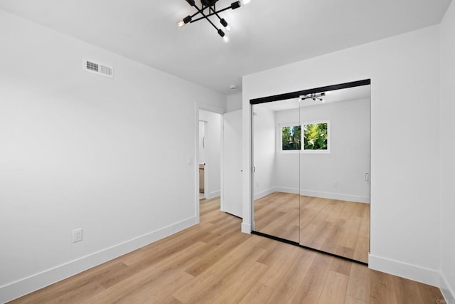 unfurnished bedroom with light hardwood / wood-style floors and a closet