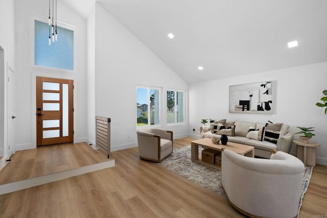 living room featuring high vaulted ceiling and light hardwood / wood-style flooring