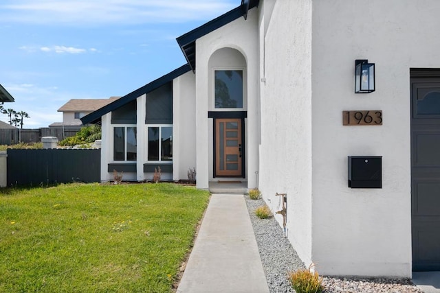 view of exterior entry with a yard