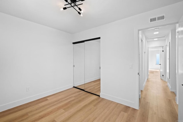 unfurnished bedroom featuring light hardwood / wood-style floors and a closet