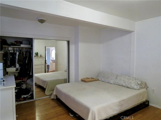 bedroom featuring hardwood / wood-style floors and a closet