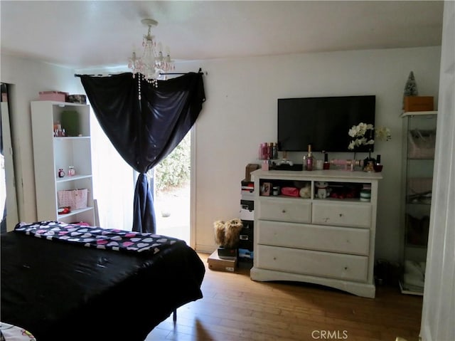 bedroom with a chandelier and hardwood / wood-style floors