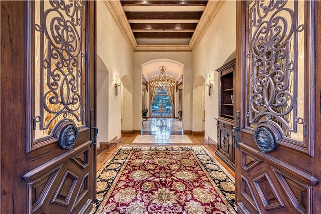 22931 Sonriente Trl, Coto De Caza, CA 92679 - entryway with arched walkways, baseboards, a high ceiling, a chandelier, and ornamental molding