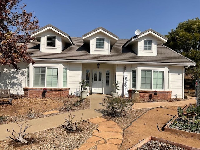 view of front facade with brick siding and a vegetable garden