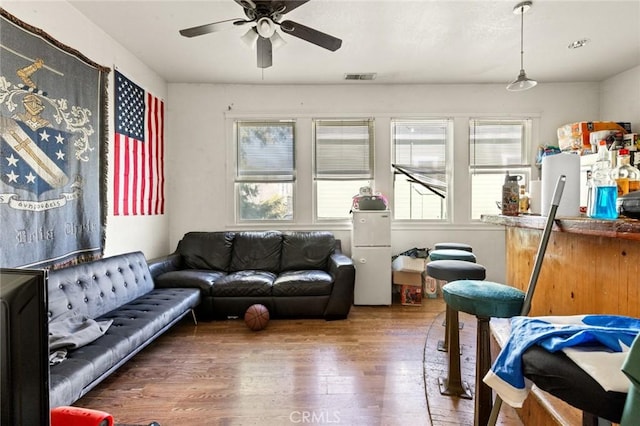 living room with wood-type flooring and ceiling fan