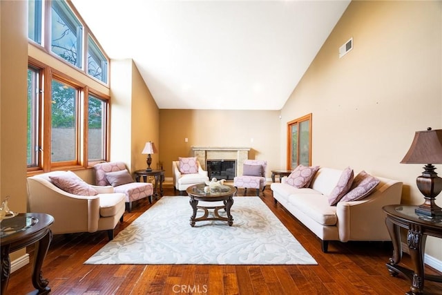 living room featuring a high end fireplace, dark hardwood / wood-style floors, and high vaulted ceiling