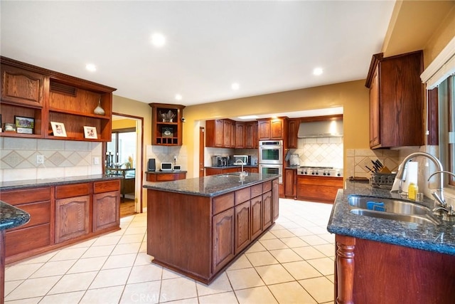 kitchen with wall chimney range hood, a kitchen island with sink, sink, and light tile patterned floors