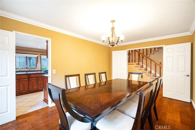 dining space with an inviting chandelier, light hardwood / wood-style flooring, and ornamental molding