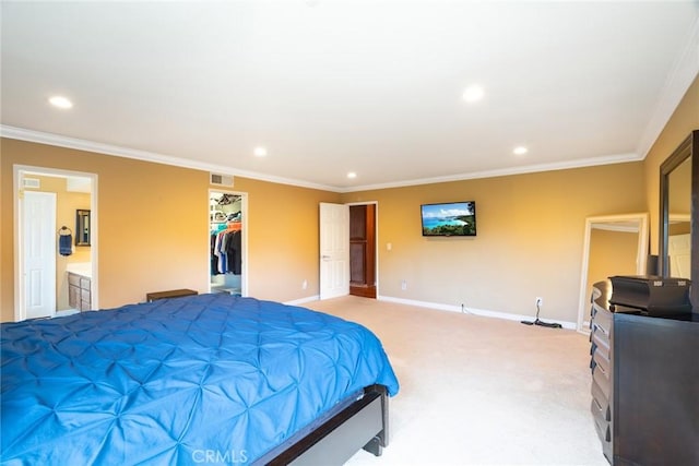 carpeted bedroom with ornamental molding, a walk in closet, ensuite bath, and a closet