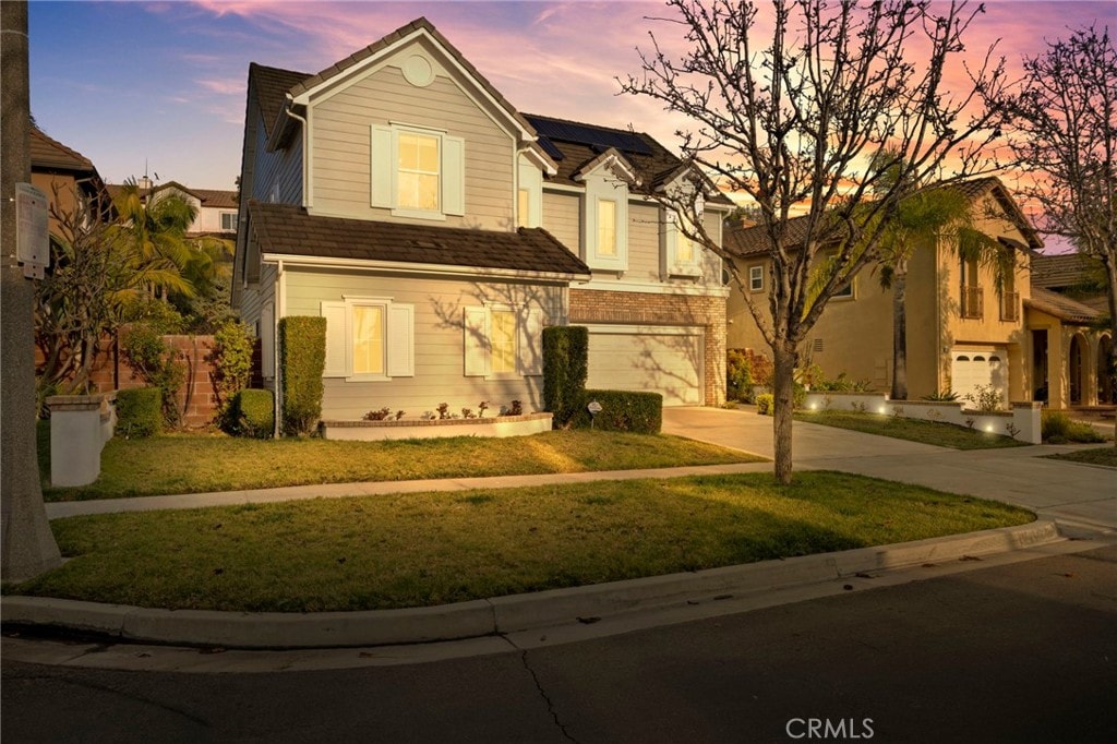 view of front of property featuring a garage and a lawn