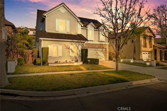 view of front of property featuring a garage and a lawn