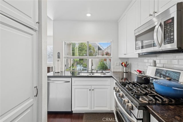 kitchen featuring tasteful backsplash, sink, white cabinets, and appliances with stainless steel finishes