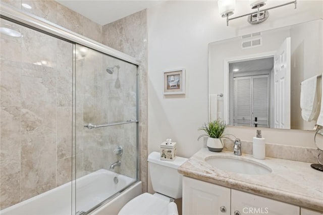 full bathroom with shower / bath combination with glass door, vanity, and toilet