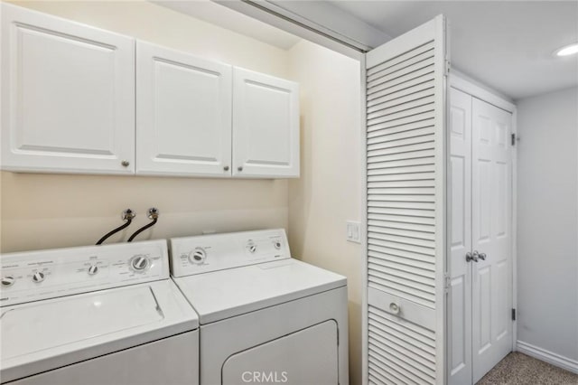 laundry area featuring cabinets, washer and dryer, and light carpet